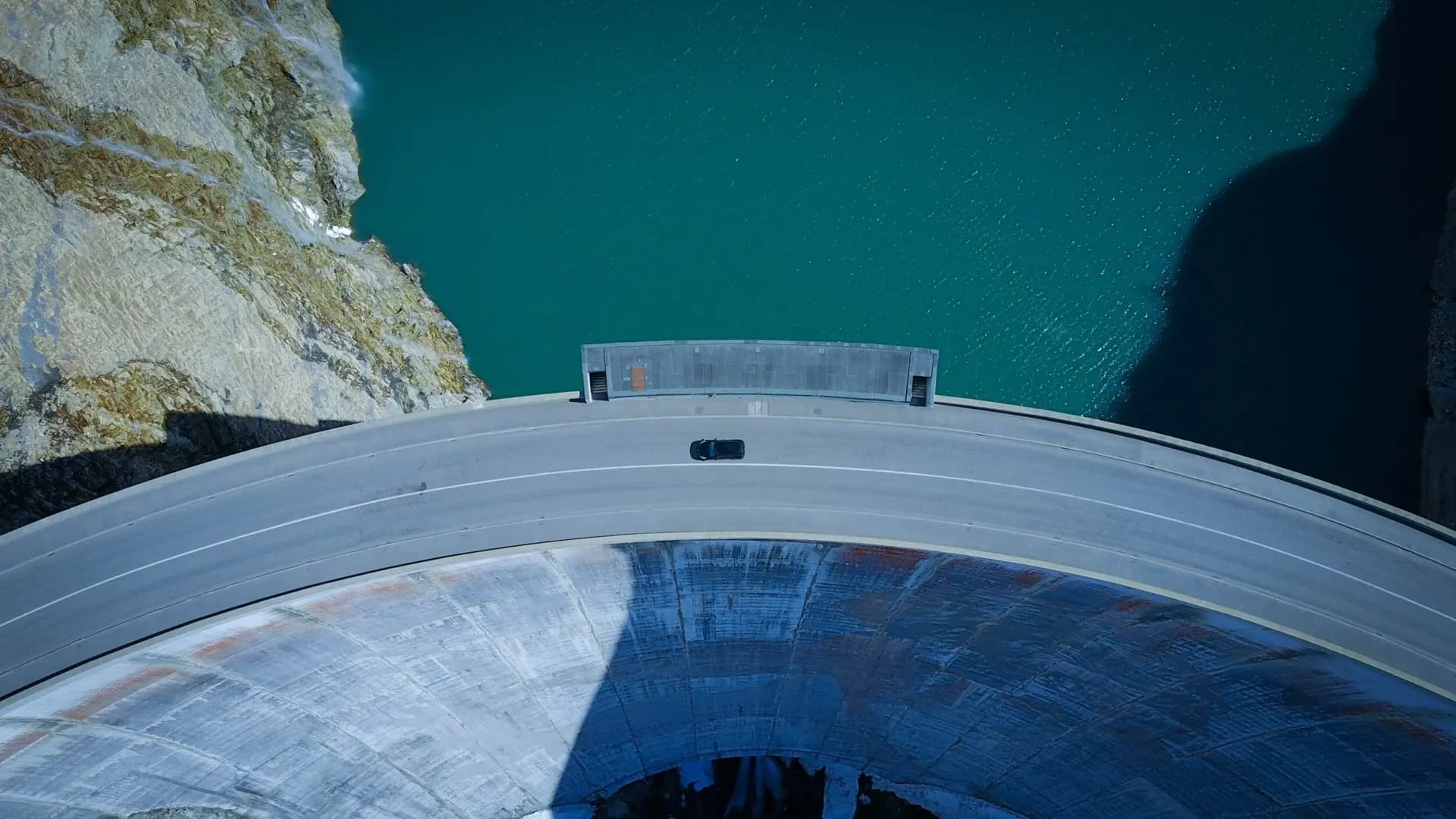 Drone view straight down onto the crest of a concrete arch dam